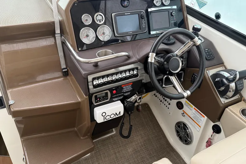 Slide: The Image of 2015 Formula 310 Sun Sport boat dashboard with steering wheel and navigation controls. - 10