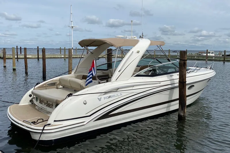 Slide: The Image of 2015 Formula 310 Sun Sport boat docked in a marina, featuring sleek design and luxury amenities. - 2