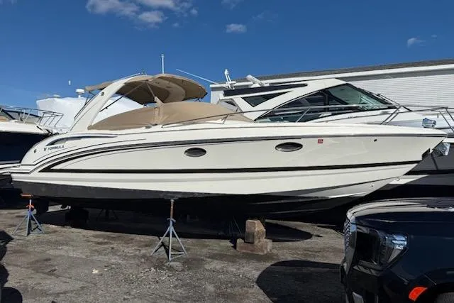 Slide: The Image of 2015 Formula 310 Sun Sport boat on stands, under clear blue sky. - 22