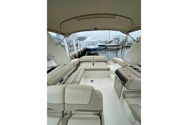 Slide: The Image of 2015 Formula 310 Sun Sport boat interior with seating and canopy at a marina. - 4