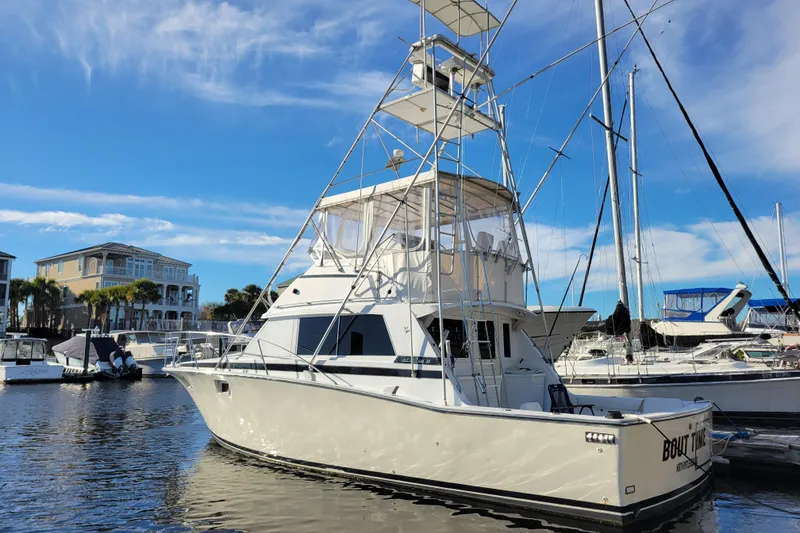 The Image of 1979 Bertram 38 Convertible yacht docked in a marina under a clear blue sky. - 0