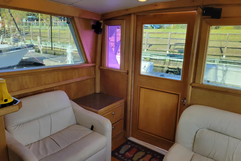 Slide: The Image of Interior of 1979 Bertram 38 Convertible yacht with wood paneling and white seating. - 11