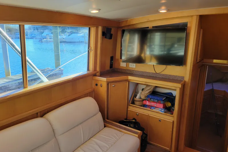 Slide: The Image of 1979 Bertram 38 Convertible yacht interior with TV, sofa, and marina view. - 14