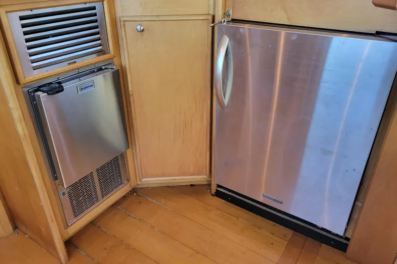 Slide: The Image of 1979 Bertram 38 Convertible interior with stainless steel appliances and wooden cabinetry. - 16
