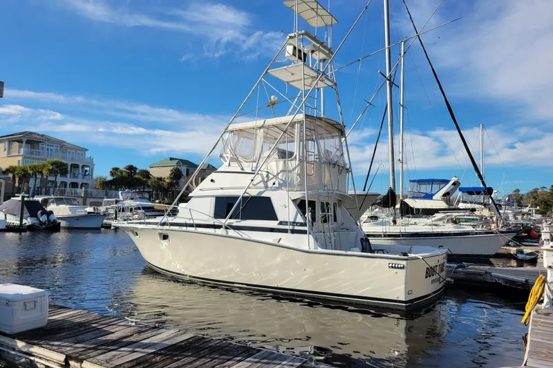 Slide: The Image of 1979 Bertram 38 Convertible yacht docked at marina under clear blue sky. - 2