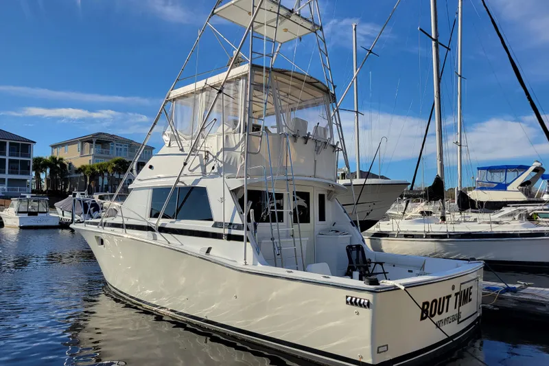 Slide: The Image of 1979 Bertram 38 Convertible yacht docked in marina under clear blue sky. - 3