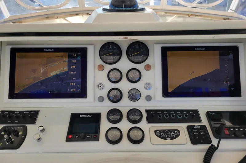 Slide: The Image of 1979 Bertram 38 Convertible boat dashboard with Simrad navigation displays and gauges. - 38