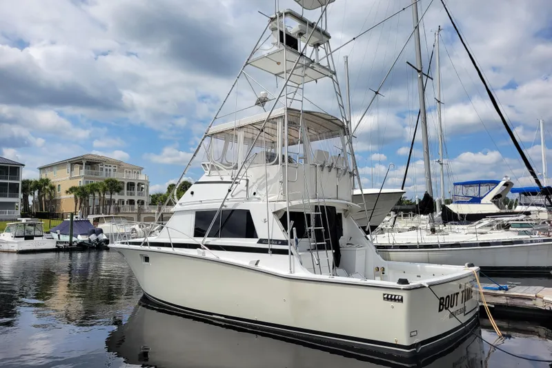 Slide: The Image of 1979 Bertram 38 Convertible yacht docked at marina under cloudy sky. - 4