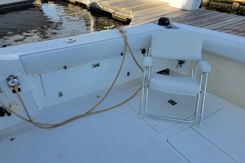 Slide: The Image of 1979 Bertram 38 Convertible boat deck with white chair and dock view. - 46