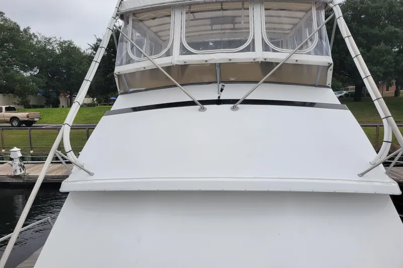 Slide: The Image of 1979 Bertram 38 Convertible boat docked, front view with enclosed flybridge. - 49