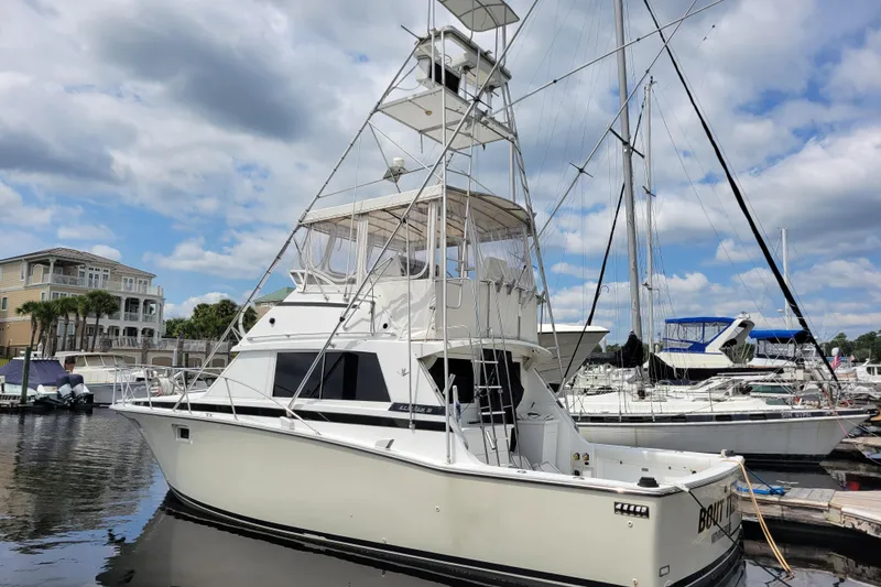 Slide: The Image of 1979 Bertram 38 Convertible yacht docked at marina under cloudy sky. - 5