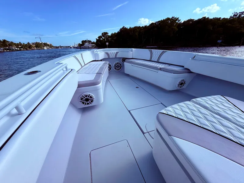 Slide: The Image of 2024 Contender 39 ST boat interior with cushioned seating, on a calm waterway. - 13
