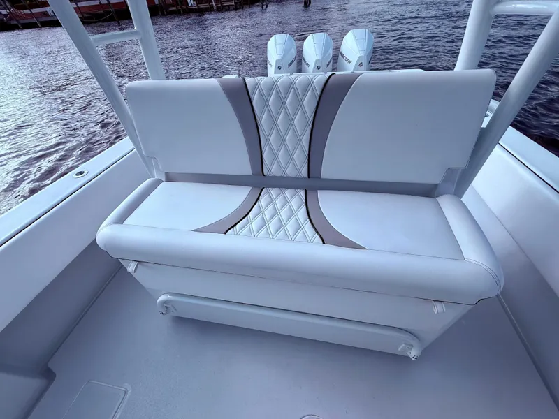 Slide: The Image of 2024 Contender 39 ST boat with stylish cushioned seating and triple outboard motors. - 16