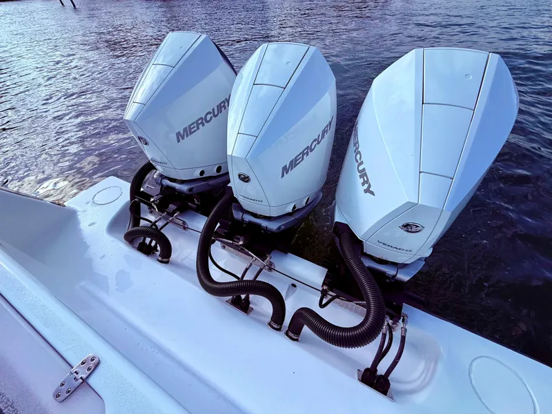 Slide: The Image of Triple Mercury outboard engines on 2024 Contender 39 ST boat, docked on water. - 20