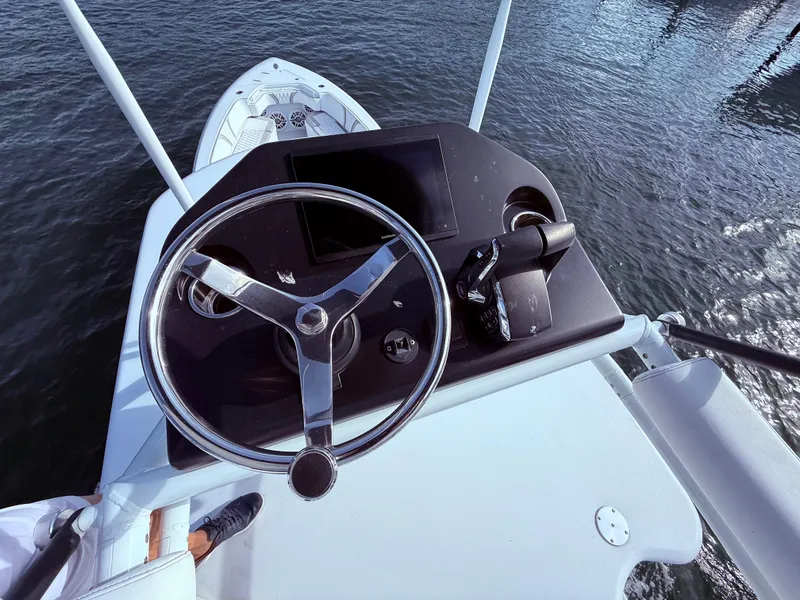 Slide: The Image of 2024 Contender 39 ST boat helm with steering wheel and controls, overlooking water. - 33