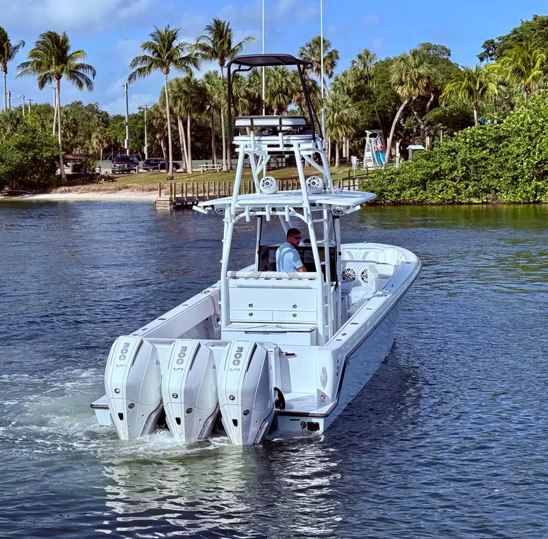 Slide: The Image of 2024 Contender 39 ST boat with triple engines cruising in tropical waters. - 4