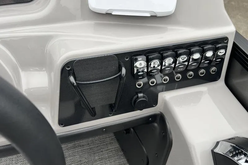 Slide: The Image of Control panel of 2025 Barletta Aria 24UC boat with switches and cup holder. - 12