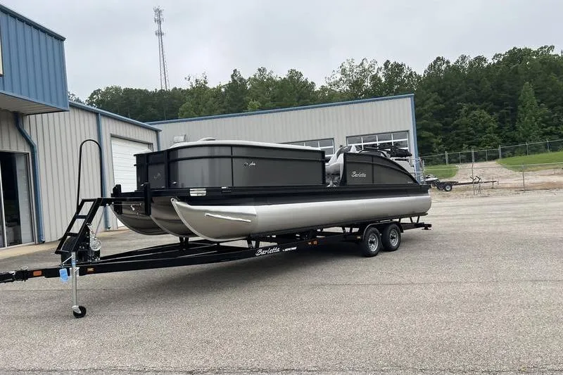 Slide: The Image of 2025 Barletta Aria 24UC pontoon boat on trailer outside a warehouse. - 5