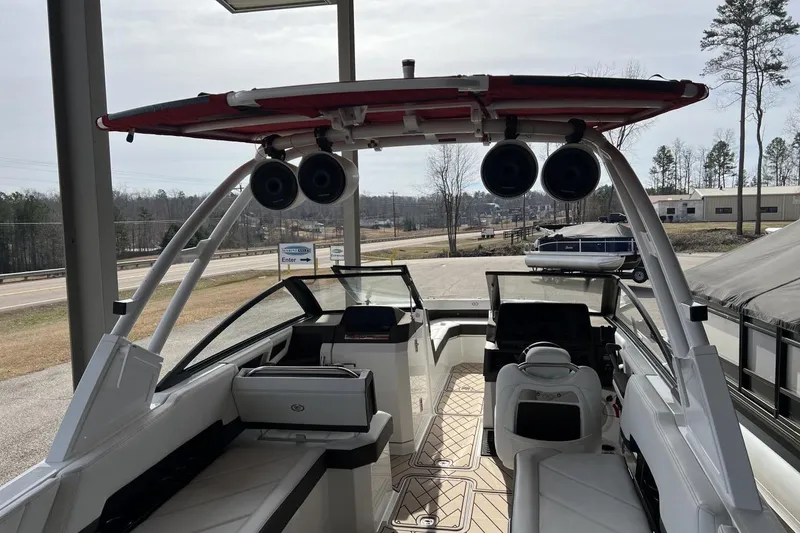 Slide: The Image of 2025 Cobalt R8 boat interior with speakers and seating, parked outdoors. - 3