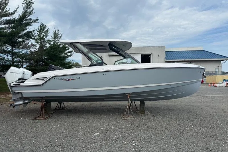 Slide: The Image of 2026 Monterey Elite 30 OB boat on stands, outdoor setting, overcast sky. - 2