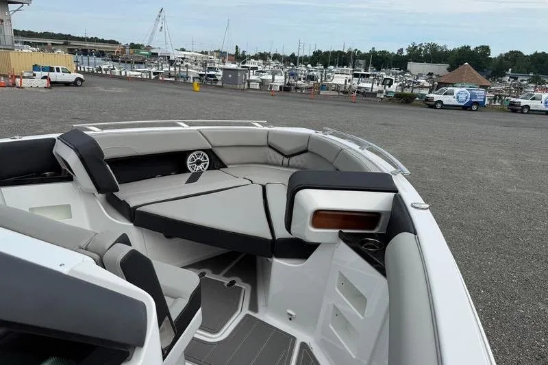 Slide: The Image of 2026 Monterey Elite 30 OB boat interior with gray seating, docked at a marina. - 5