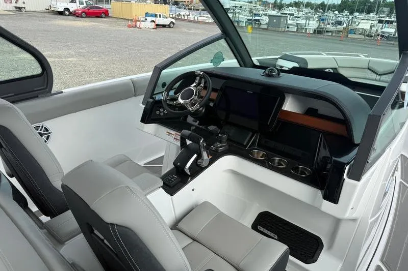 Slide: The Image of Interior of 2026 Monterey Elite 30 OB boat with modern dashboard and seating. - 9
