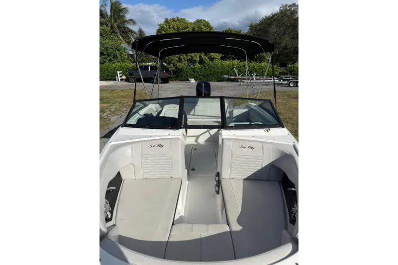 Slide: The Image of 2023 Searay SPX 190 boat interior with seating and canopy, parked outdoors. - 9