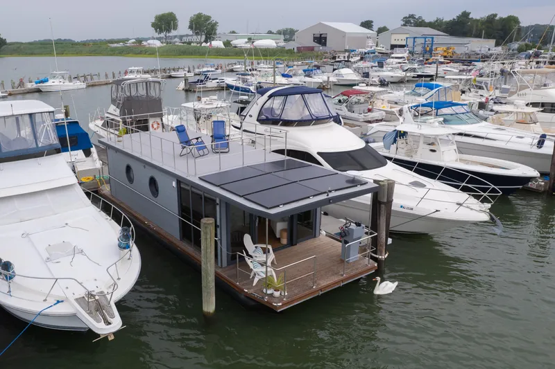 Slide: The Image of Modern Waterlodge Apart L Long houseboat docked among yachts, 2026 model. - 1