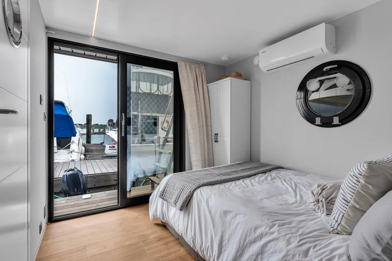 Slide: The Image of Modern Waterlodge Apart L Long 2026 bedroom with marina view, featuring cozy bed and air conditioning. - 16