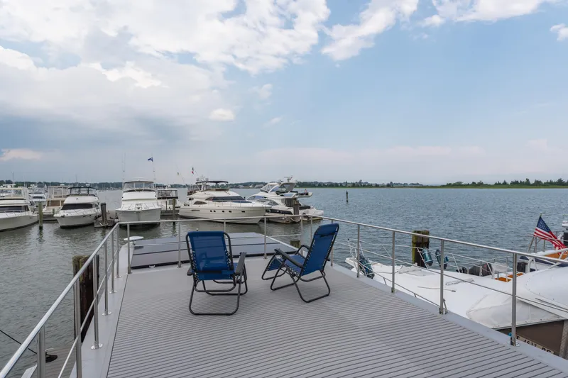 Slide: The Image of Deck view from Waterlodge Apart L Long 2026, overlooking marina with boats and serene water. - 24