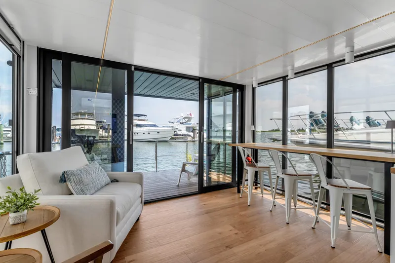 Slide: The Image of Modern Waterlodge Apart L Long 2026 interior with waterfront view, featuring cozy seating and dining area. - 8