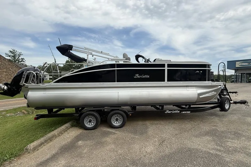 The Image of 2025 Barletta ARIA 22UC pontoon boat on trailer, parked outdoors. - 1