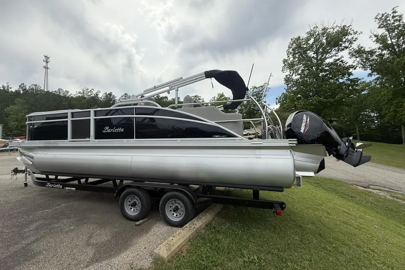 Slide: The Image of 2025 Barletta ARIA 22UC pontoon boat on trailer, parked outdoors. - 10