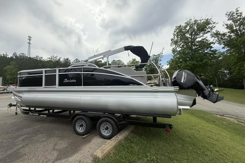 Slide: The Image of 2025 Barletta ARIA 22UC pontoon boat on trailer, parked outdoors. - 11