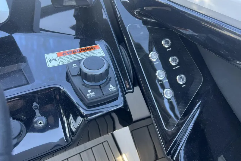 Slide: The Image of Control panel of 2025 Yamaha Boats 252SE with buttons and warning label. - 14