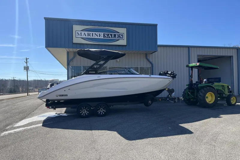 Slide: The Image of 2025 Yamaha Boats 252SE at Marine Sales, parked with a tractor under clear skies. - 22