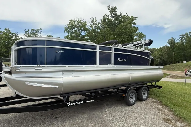 Slide: The Image of 2025 Barletta ARIA 22QC pontoon boat on trailer, parked outdoors. - 8