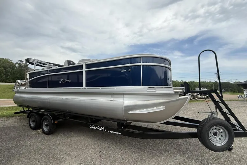 Slide: The Image of 2025 Barletta ARIA 22QC pontoon boat on trailer, parked outdoors under cloudy sky. - 9