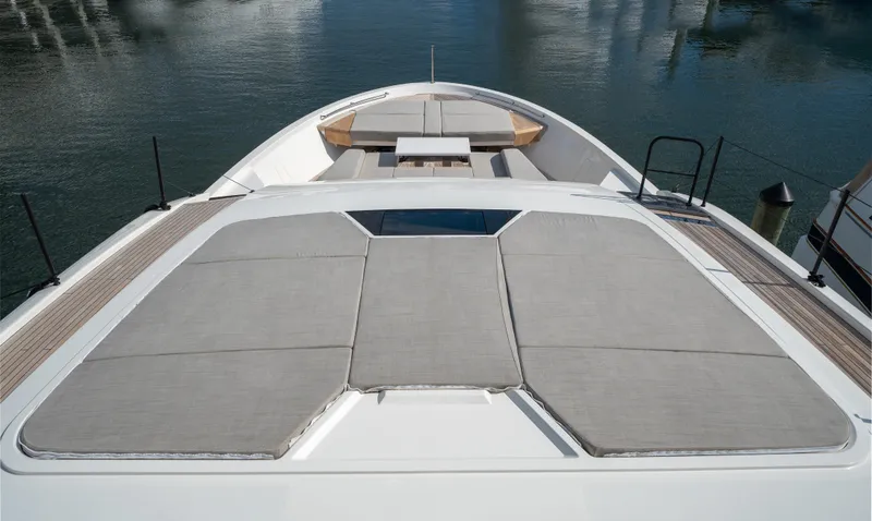 Slide: The Image of 2022 Sanlorenzo SL96A yacht deck with sunbathing area and seating, docked on calm water. - 1