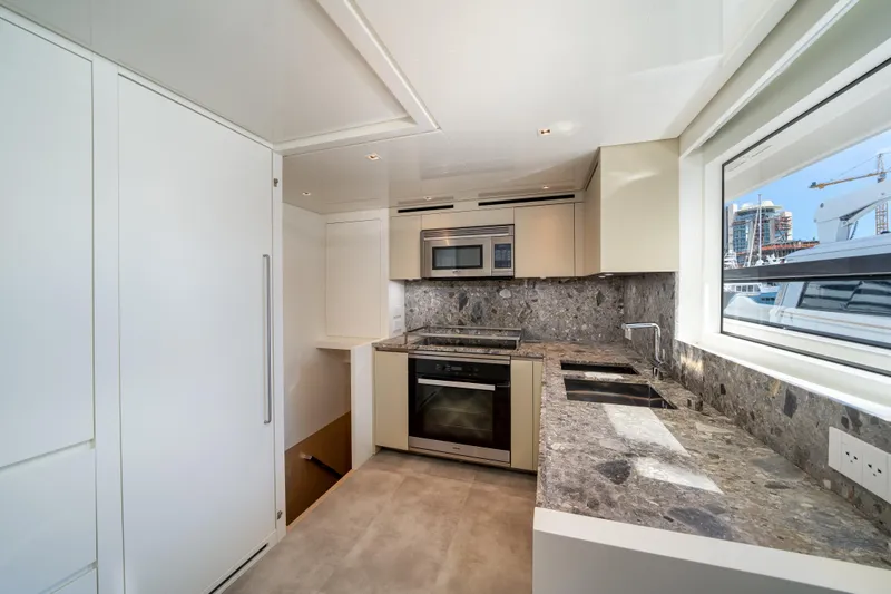 Slide: The Image of Modern kitchen interior on 2022 Sanlorenzo SL96A yacht, featuring sleek design and marble countertops. - 14