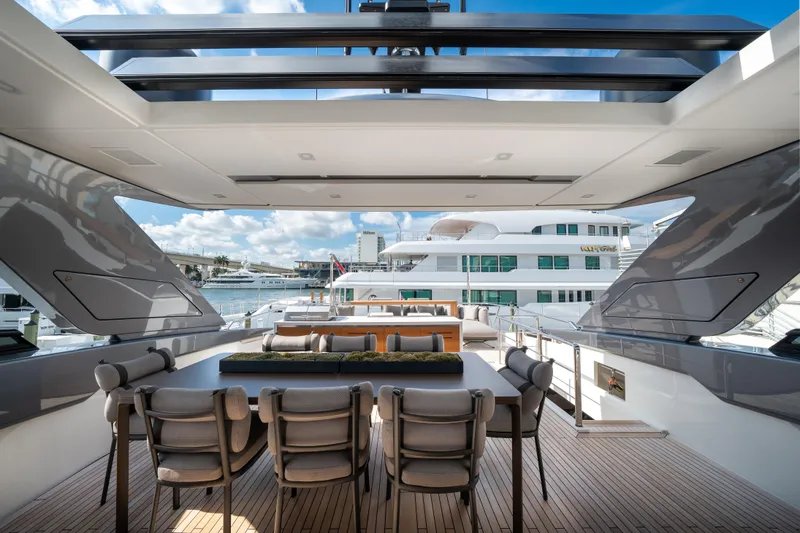 Slide: The Image of Luxurious 2022 Sanlorenzo SL96A yacht deck with elegant dining area and scenic marina view. - 5