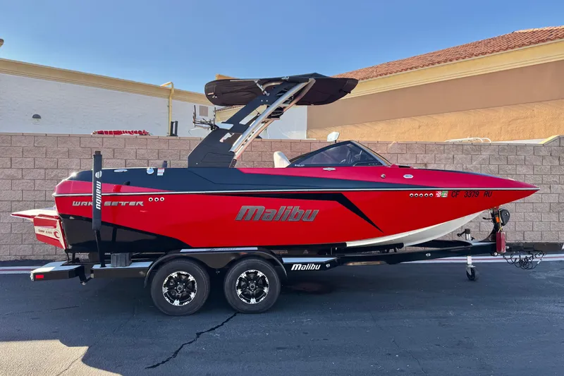 The Image of 2018 Malibu Wakesetter 21 MLX boat in vibrant red on a trailer. - 0