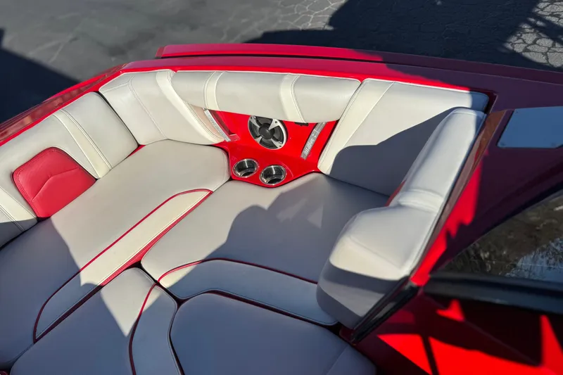 Slide: The Image of 2018 Malibu Wakesetter 21 MLX interior with red and white seating, cup holders, and speaker. - 16