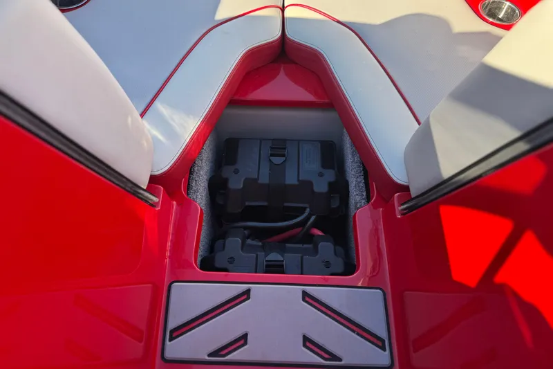 Slide: The Image of Battery compartment of 2018 Malibu Wakesetter 21 MLX boat, featuring red and gray interior. - 17