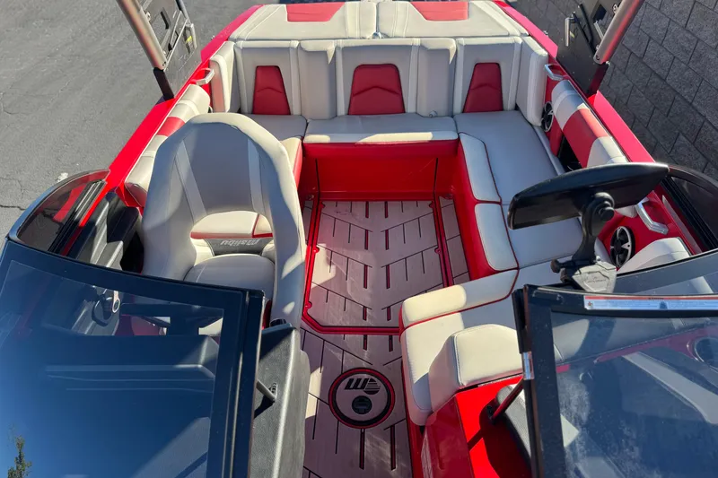 Slide: The Image of 2018 Malibu Wakesetter 21 MLX interior with red and white seating, steering wheel, and dashboard. - 18