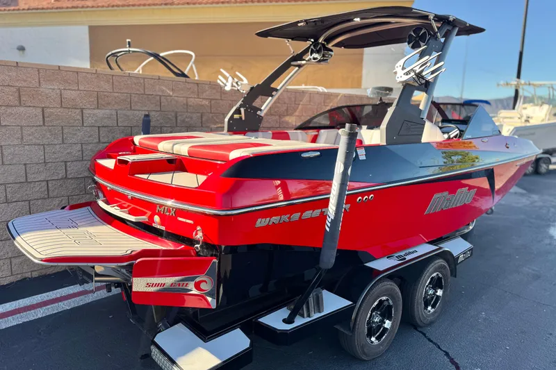 Slide: The Image of 2018 Malibu Wakesetter 21 MLX boat in vibrant red, parked on a trailer. - 5