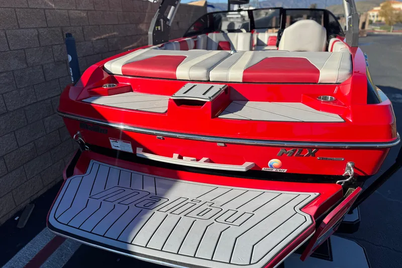 Slide: The Image of 2018 Malibu Wakesetter 21 MLX boat, red exterior, rear view with swim platform. - 6