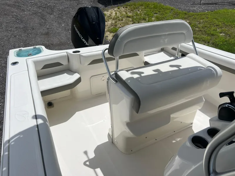 Slide: The Image of 2021 Sailfish 242 CC boat interior with seating and motor, in sunlight. - 14