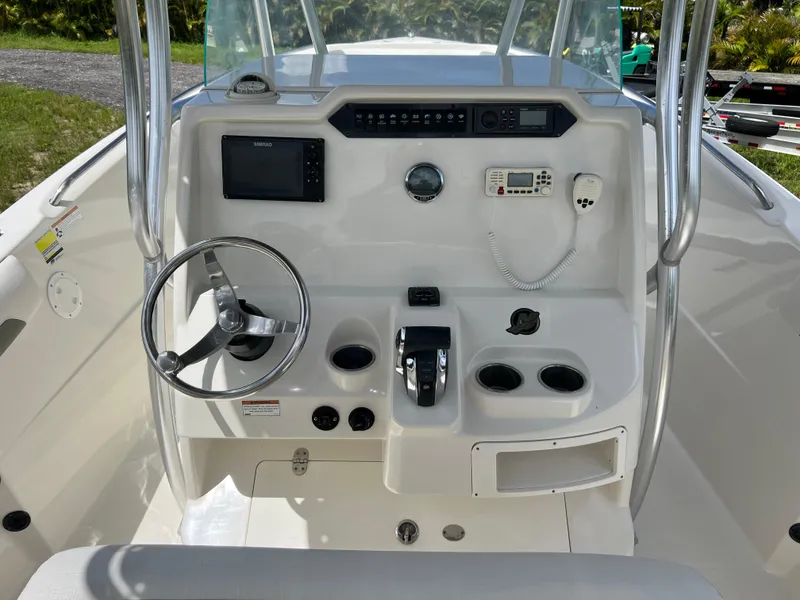 Slide: The Image of 2021 Sailfish 242 CC boat console with steering wheel, controls, and electronics. - 19