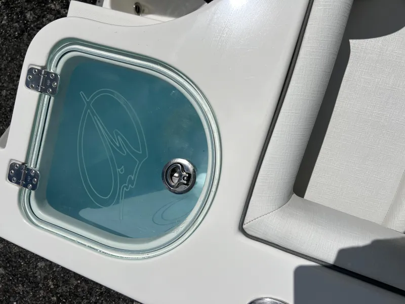 Slide: The Image of 2021 Sailfish 242 CC boat livewell with logo and cushioned seating. - 23